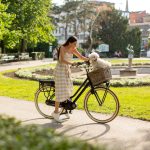 Woman Bikes with Dog in Park on Sunny Day