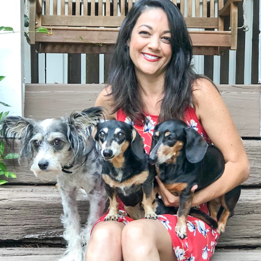 sunniduke woman holding three dogs after being reunited after international travel