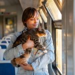Woman traveling by train holding her cat